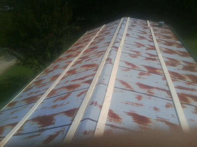 Rusted metal roof panels with new wood purlins before replacement — Storm Damage Roof Repair in Bowling Green by Roofing Brothers