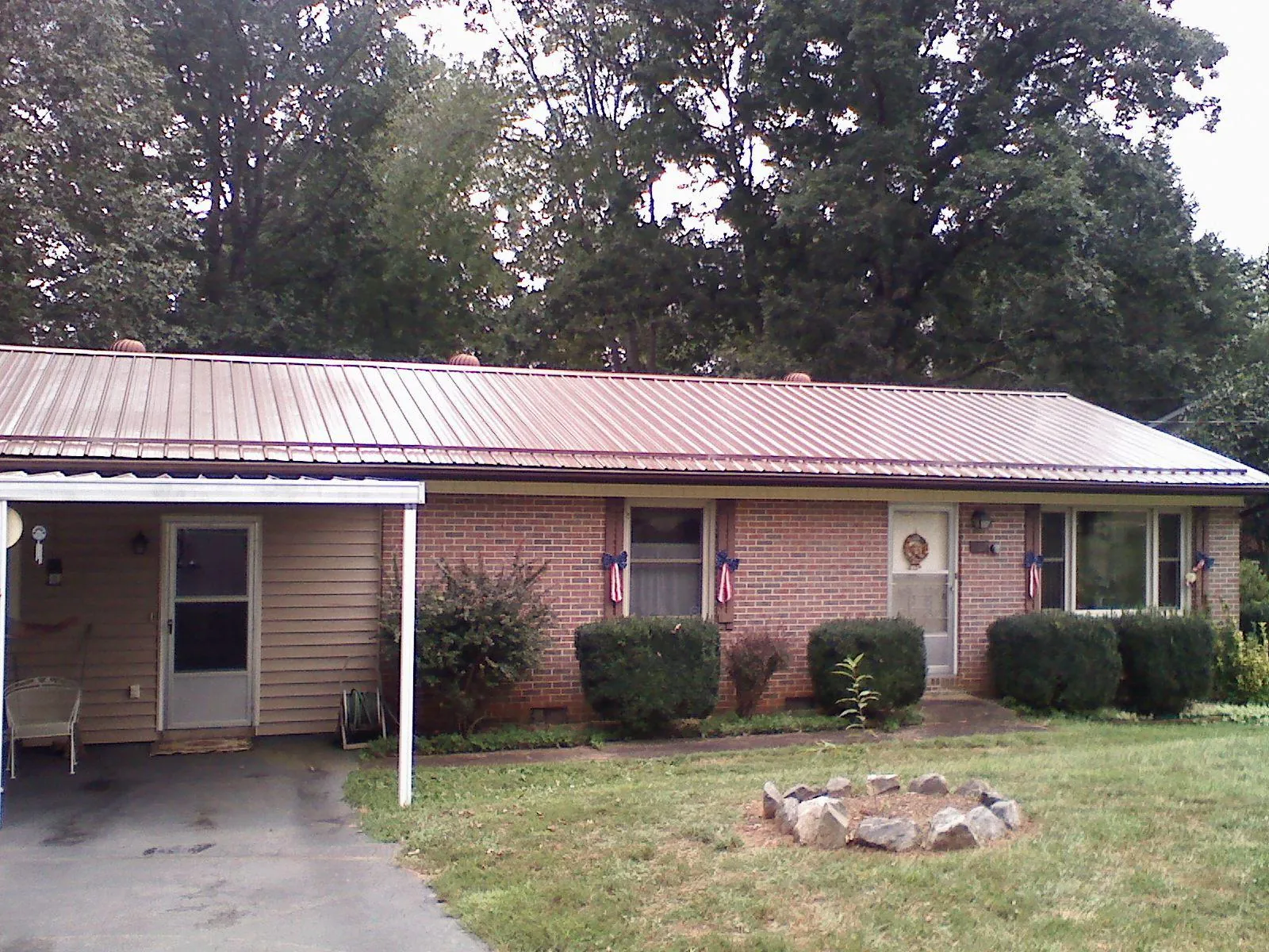 Bronze metal roof and carport on a brick ranch home — Roof Repair work by our crew in Bowling Green
